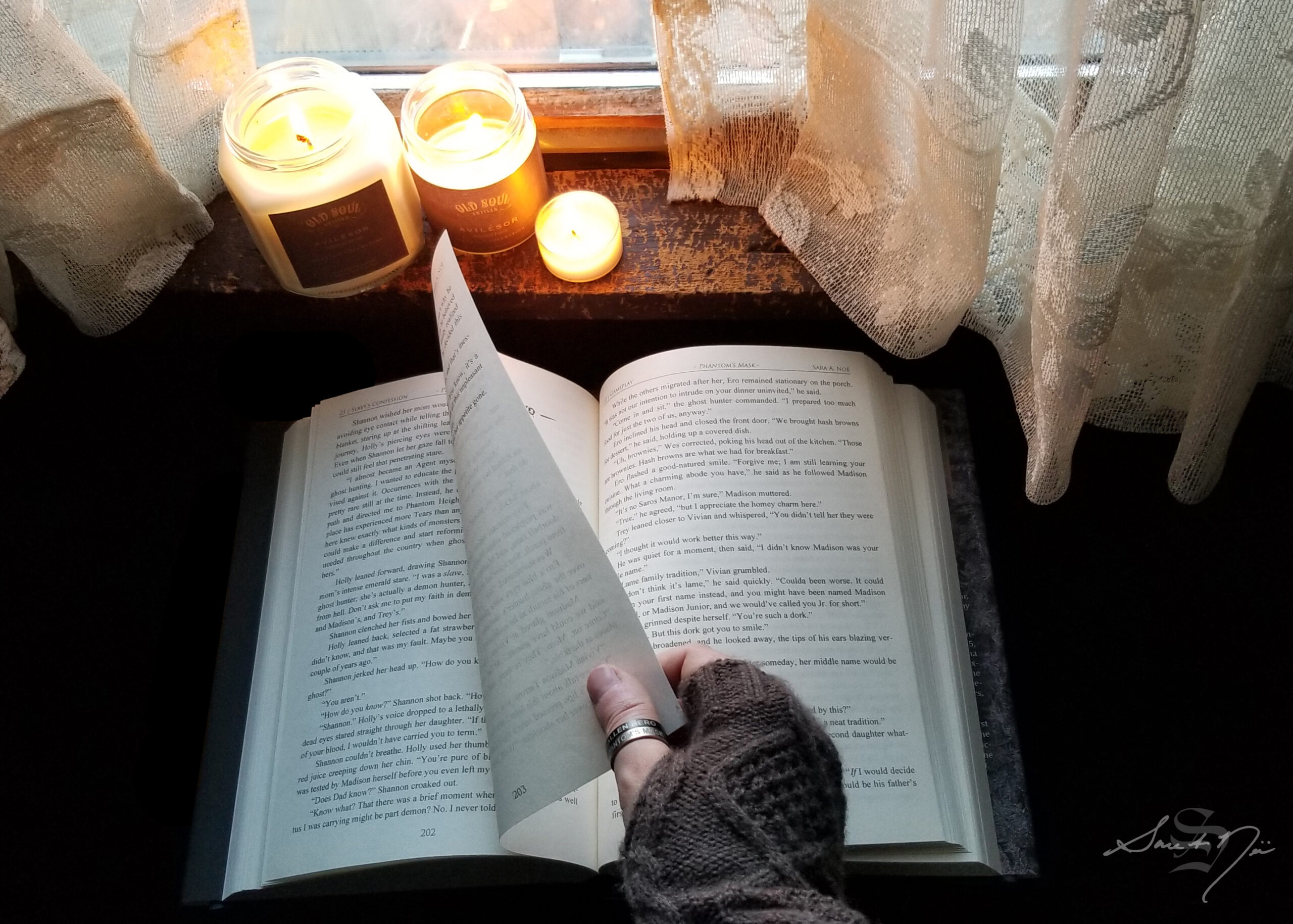 Turning a book page with candles burning