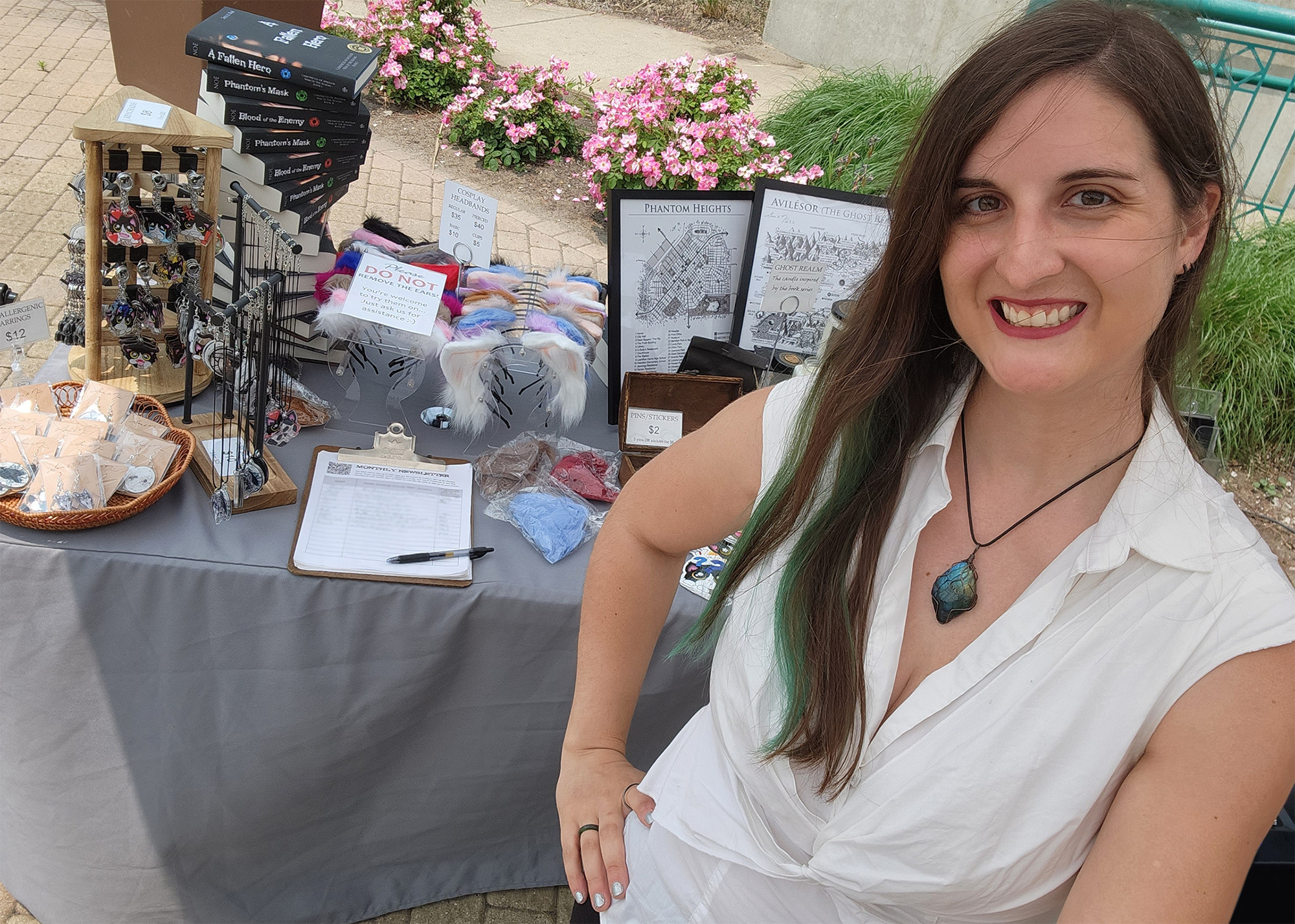 Author and artist Sara A. Noe standing in front of her booth at an outdoor market